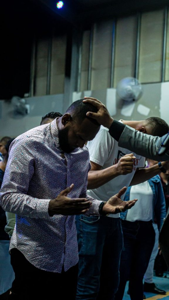 Men engaged in a spiritual prayer gathering inside a worship venue, reflecting devotion.